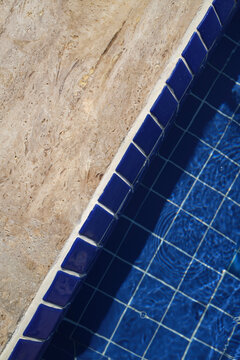 Tranquil blue tiles outlining a swimming pool under bright sunlight