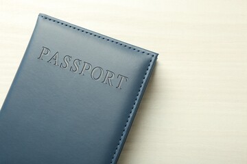 Passport in grey cover on white wooden table, top view. Space for text