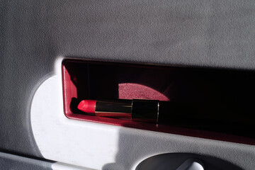 Red lipstick resting in a plane's table 