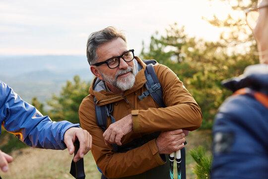 Friends conversing on a mountain at sunset