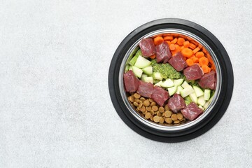 Dry pet food and natural products on light table, top view. Space for text