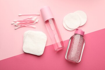 Cotton pads, swabs and cosmetic products on pink background, flat lay