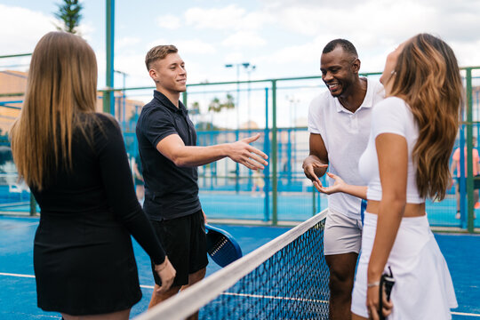 Padel players shake hands after a match on the court.