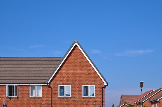 Clear blue sky above a suburban house with a triangular roof