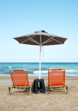 Empty sunbeds with parasol on the beach 