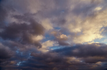 Contrast of a winter day: gray clouds gently lit by sunlight on a blue background.