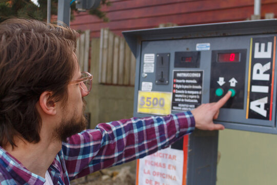 Man Using Air Pump Machine at Gas Station