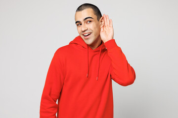 Young curious nosy middle eastern man he wear red hoody casual clothes try to hear you overhear...