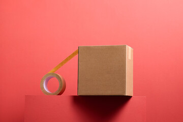 Brown Cardboard Box with Packing Tape on Red Background