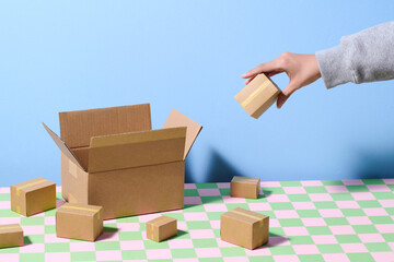 Hand Arranging Cardboard Boxes on Colorful Table