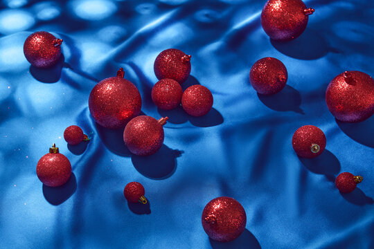 Glittering Red Christmas Ornaments on Blue Fabric Background