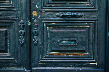 Weathered wooden door with ornate handles