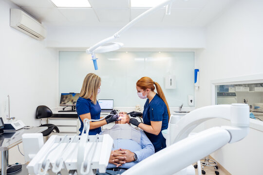 Professional dentists providing patient care in modern clinic
