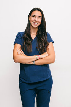 Confident Dentist Smiling in Professional Attire with Arms Crossed