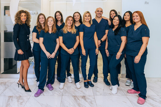 Dedicated dental professionals posing in modern clinic setting