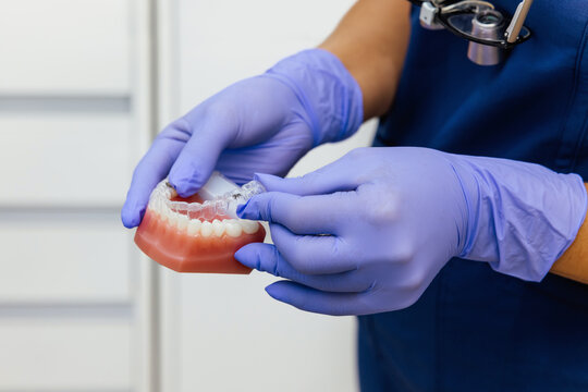 Dentist demonstrating clear aligner fitting in clinic