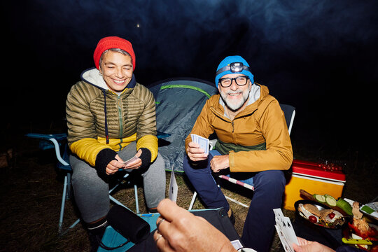 Friends engage in a game of cards at the camp