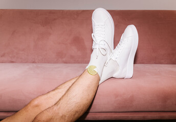 Relaxed Legs in White Sneakers on Pink Sofa
