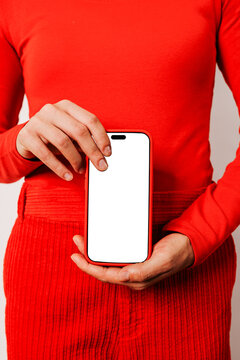 Woman showing smartphone with blank screen wearing red clothes
