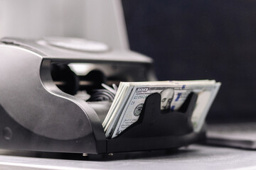 Close-up of dollar bills in an automatic cash register, perfect for financial, banking, and...