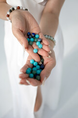 a bracelet made of natural stones in women's hands. photo. vertical