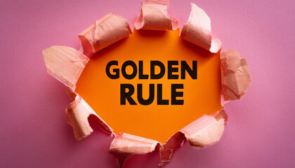 golden rule message written on ripped torn pink paper piece with orange heritage conceptual golden rule symbol replica space