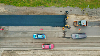 Aerial View of Road Paving with Traffic Nearby. Aerial shot of workers paving a road with fresh...