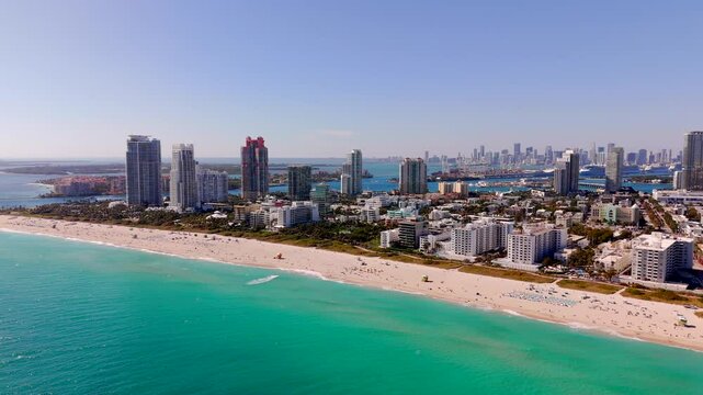 2025 stock footage Miami. Aerial drone video view of beach and highrise towers by port inlet. Scenic Miami Beach video commercial licensing