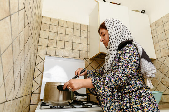 Afghan woman cooking at the kitchen 