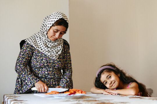 Afghan mother cutting julienne carrots with daughter