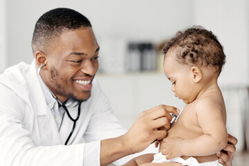 Black Pediatrician Doctor Doing Check Up To Cute Newborn Baby In Diaper, African American Pediatrist Using Stethoscope For Listening Child's Heartbeat, Checking Infant's Heart And Lungs In Clinic