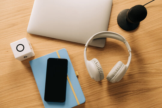 Close up of podcast recording essentials on wooden desk