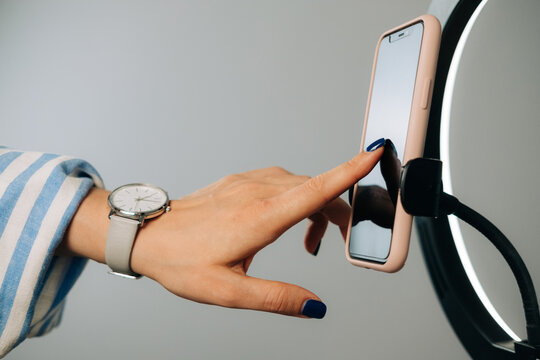  Close up of female hand on smartphone while preparing for video