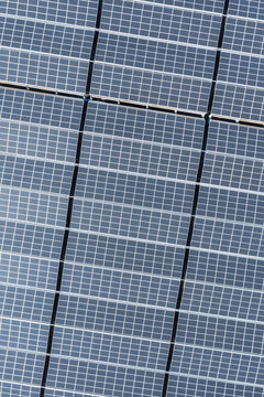 Aerial View of Solar Panels in Grid Pattern Reflecting Sunlight