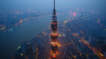 Bright lights illuminate the skyline of Shanghai at dusk with a focus on a tall tower