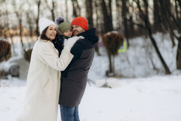 Happy family walking in the winter forest