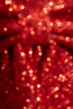 Blurred red glitter bow creating bokeh effect with lights