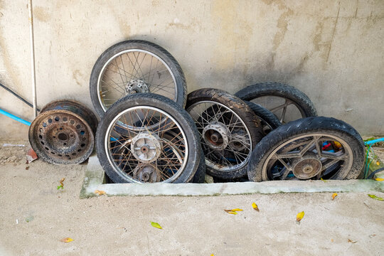 Rusty Motorcycle Wheels Piled by a Wall in Maafushi