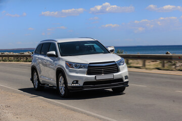 SUV drives along a road along the sea coast