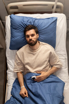 Sick patient lying in hospital bed recovering from illness