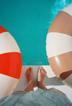 A woman by the swimming pool with two swimming rings