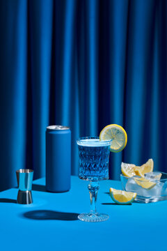 Elegant Blue Cocktail with Lemon Garnish on Vibrant Background