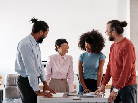 Diverse Team Collaborating Happily Around Office Table