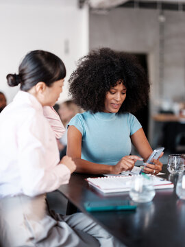 Business Women Using Phone In Modern Office Setting