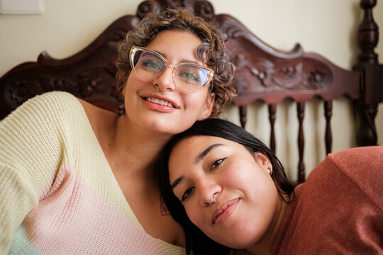 Lgbtq+ couple relaxing together in bedroom showing love and affection