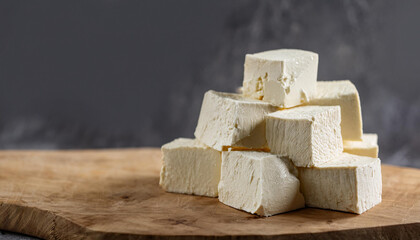 Fresh homemade tofu on wooden board. Tasty food. Cooking and culinary concept.