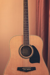 Obraz premium Classical acoustic guitar indoors, with a warm background. Musical comfort