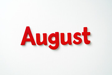 The text "August" is written in red block letters on a white background. Signboard, calendar. Advertising banner