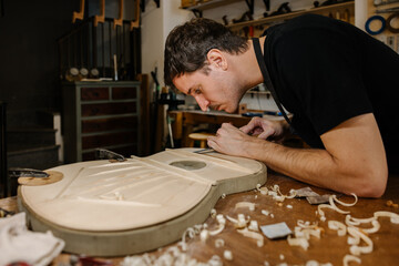 Young luthier crafting Spanish flamenco guitars with precision