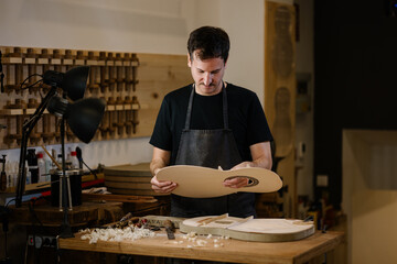 Young luthier crafting Spanish flamenco guitars with precision